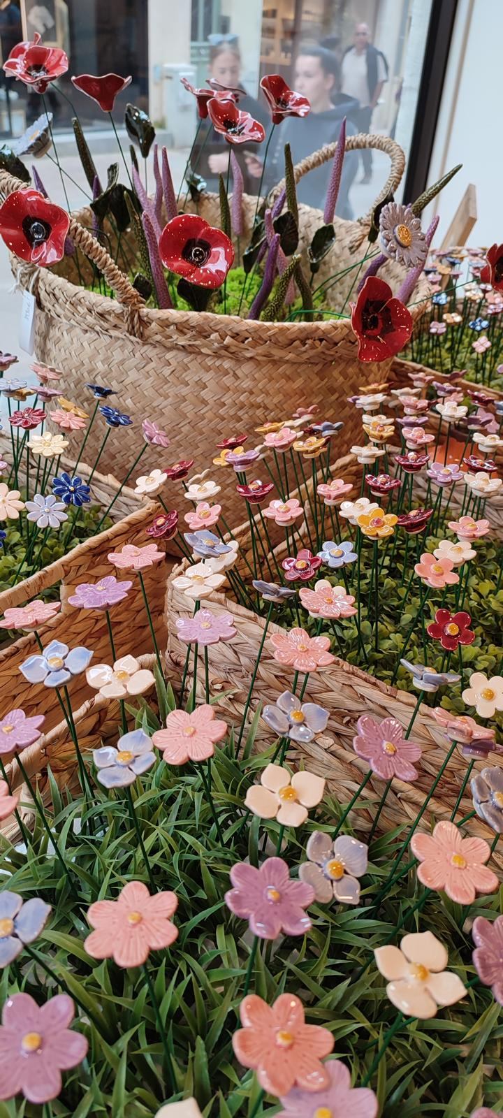 Fleurs décoratives en céramique présentées dans des paniers